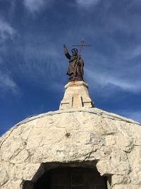 Low angle view of statue against blue sky