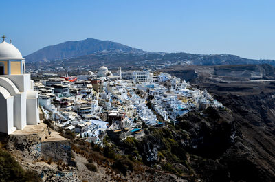 Aerial view of town by sea against clear blue sky