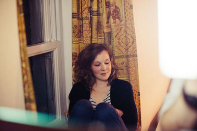 Portrait of young woman sitting at home