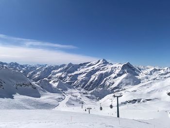 Scenic view of snowcapped mountains against blue sky