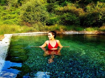 Full length of woman relaxing on lake