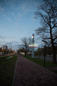 Footpath in city against sky