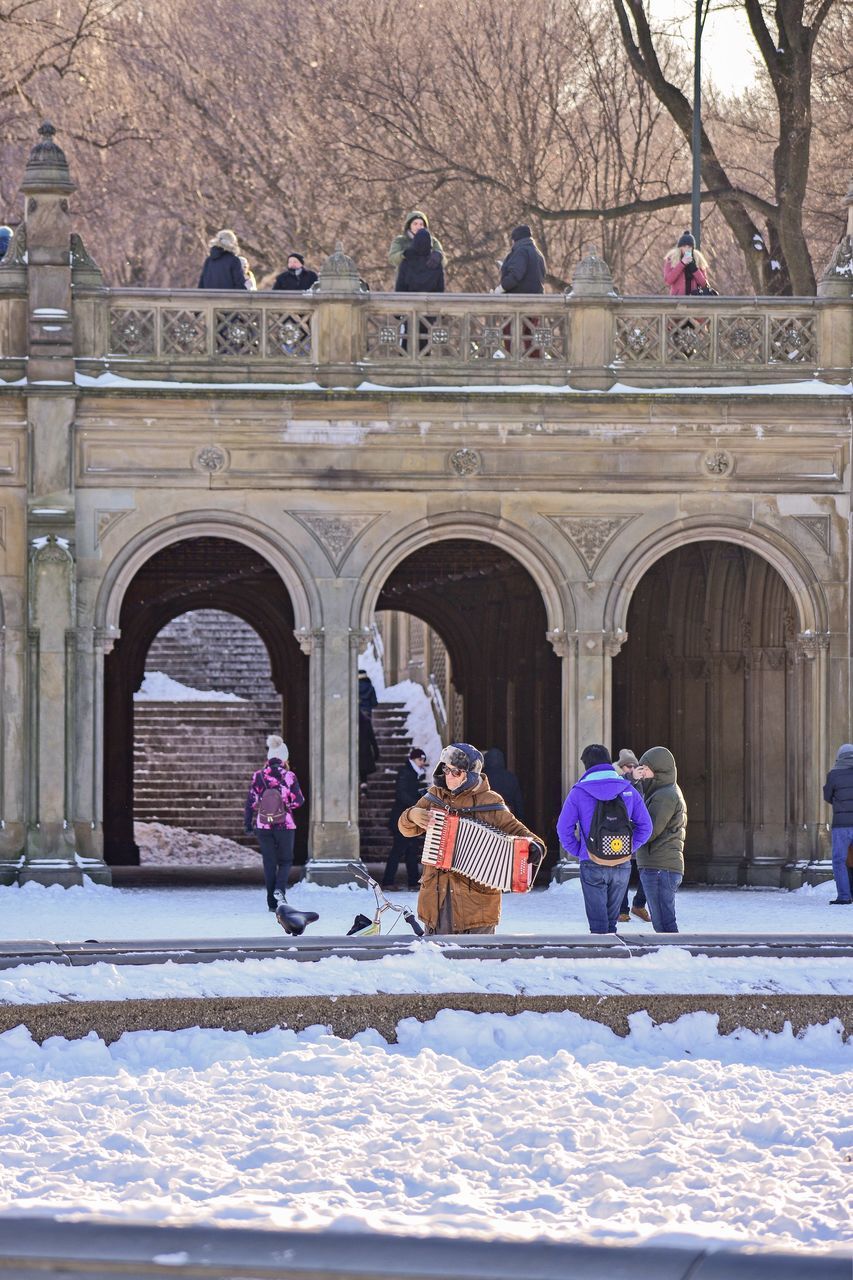 PEOPLE ON SNOW COVERED BUILDINGS