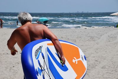 Rear view of shirtless man on beach