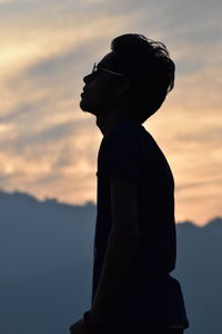 Side view of silhouette man against sky during sunset