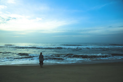 Woman standing on beach against sky