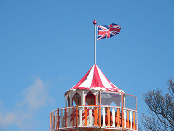 Low angle view of flag against clear blue sky