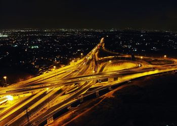 High angle view of light trails on roads in city at night