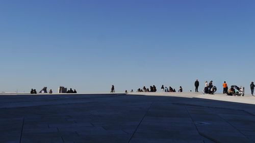 Group of people against clear blue sky