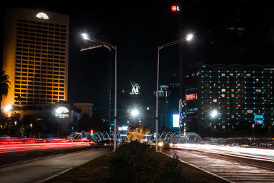 Illuminated city street and buildings at night