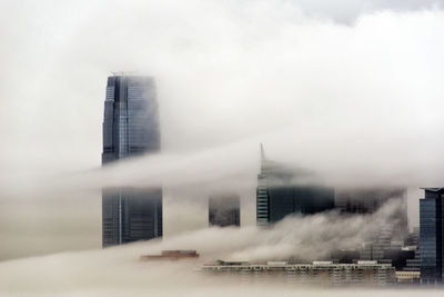 View of skyscrapers covered with clouds