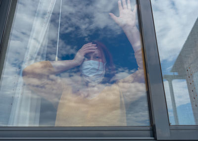 Portrait of woman seen through glass window
