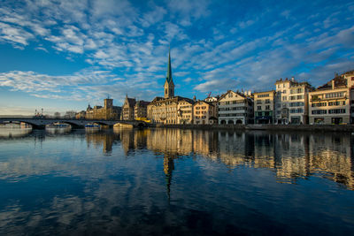 Reflection of church in river against blue sky