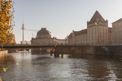 Bridge over river against buildings in city