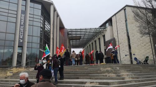 People walking on staircase against buildings in city