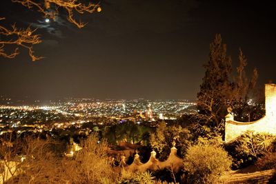 High angle view of illuminated cityscape against sky at night