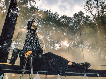 Silhouette woman by plants against sky during rainy season