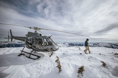 Helicopter pilot explores a snow-covered mountain summit.