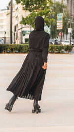 Rear view of woman walking on street in city