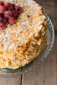 High angle view of almond cake with raspberries in plate