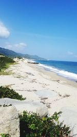 Scenic view of beach against blue sky