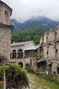 Old building by mountain against sky