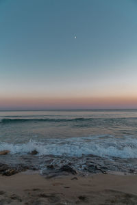 Scenic view of sea against clear sky at sunset