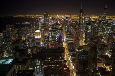 Illuminated cityscape against sky at night