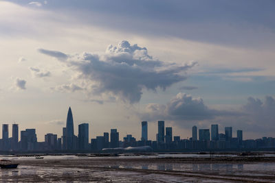 Modern buildings in city against sky during sunset