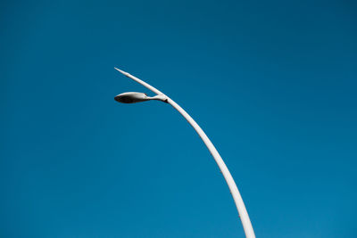 Low angle view of vapor trail against clear blue sky