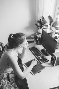 High angle view of woman working on computer at home