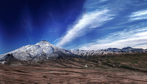 Scenic view of snowcapped mountains against blue sky