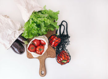 Tomatoes , green salad and red peppers on white background