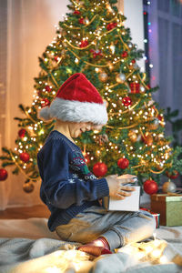 Rear view of woman decorating christmas tree