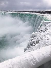 Scenic view of waterfall against sky