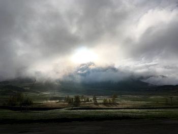 Scenic view of field against cloudy sky