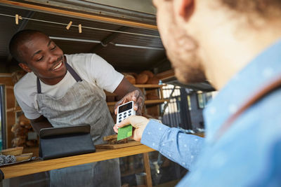 Man with credit card paying salesman at food truck