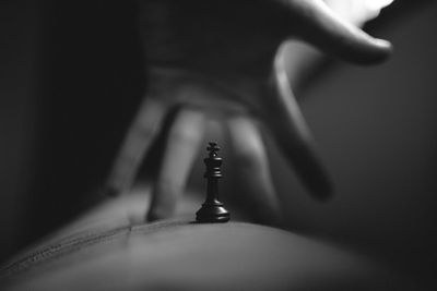 Close-up of hand holding faucet against blurred background