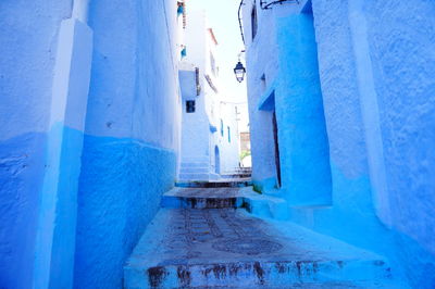 Snow covered alley amidst buildings in city