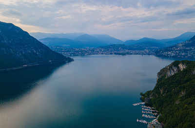 Scenic view of sea by mountains against sky