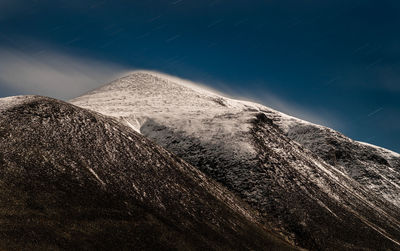 Scenic view of snowcapped mountains against sky at night