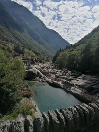 Scenic view of river and mountains against sky