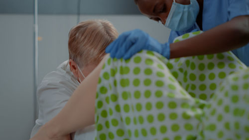 Midsection of doctor examining patient in hospital