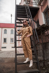 Full length outside portrait of fashion model in sunglasses, beige summer spring suit in urban area