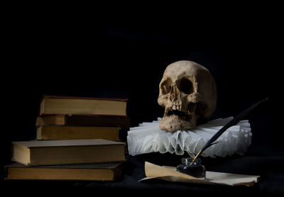 Portrait of woman sitting against black background