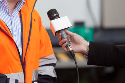 Cropped image of reporter taking interview of man