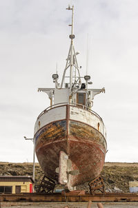 Stern view of a boat with a wooden hull for repair at a shipyard