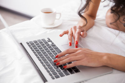 Midsection of woman using laptop on table