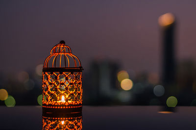 Golden lanterns with dusk sky and city bokeh light background for ramadan kareem.