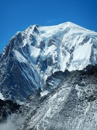 Scenic view of snowcapped mountains against clear blue sky